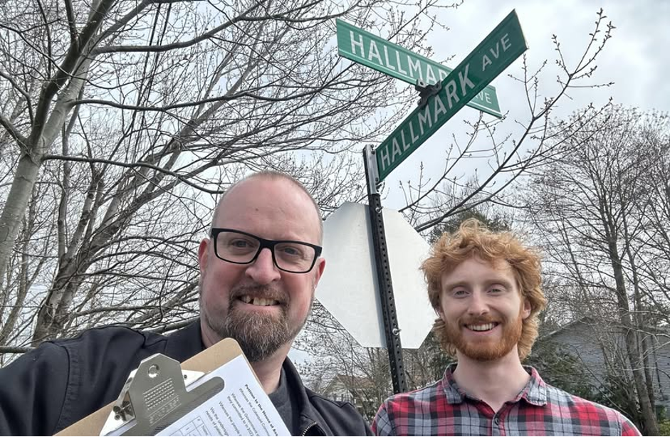 Paul standing with assistant Alex while collecting signatures.